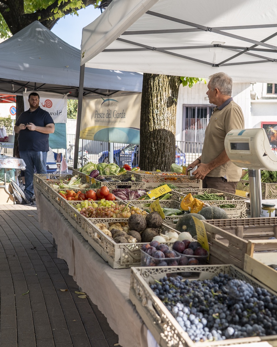 Banchi di frutta e verdura sotto i gazebo del mercato